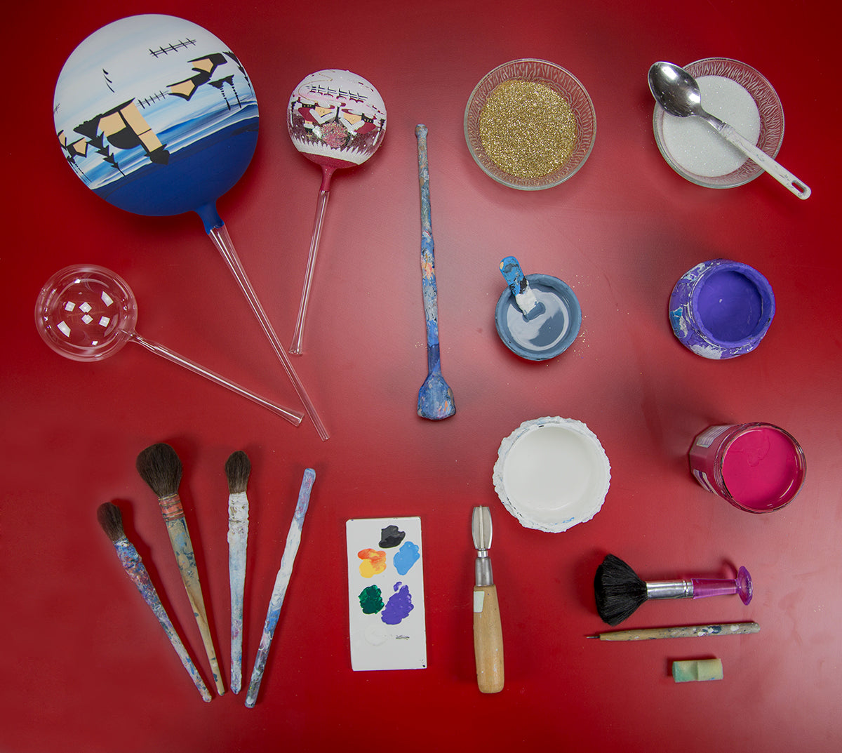 A painter work table with all the utensils to paint glass ornaments by hand.